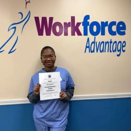 Carina Normil holding her CNA training certificate at WorkForce Advantage